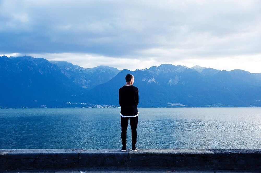 Anxious man over thinking and staring out across a lake